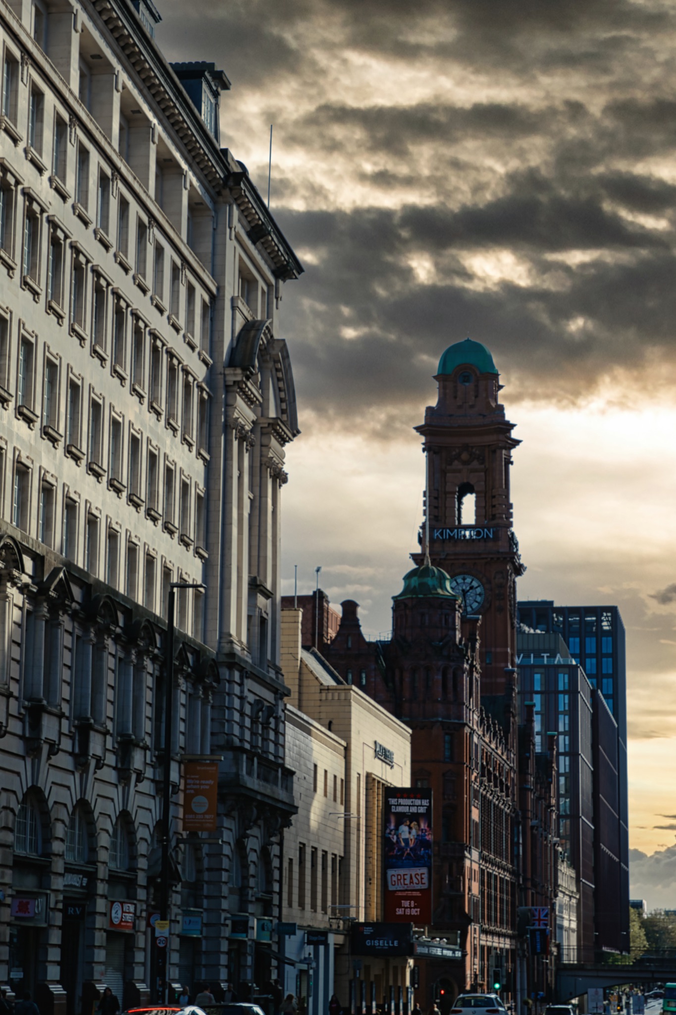 City Street with Tall Buildings and Overcast Sky in Manchester, UK.